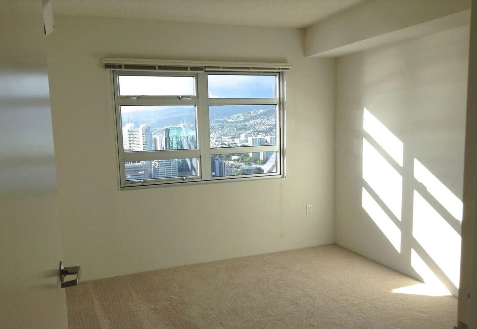 A room with a large window overlooking a cityscape.